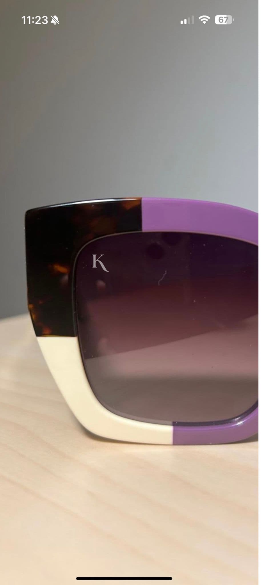 A color-blocked KOHL frame in tortoise, iris and bone, the monogram etched into the gradient lens