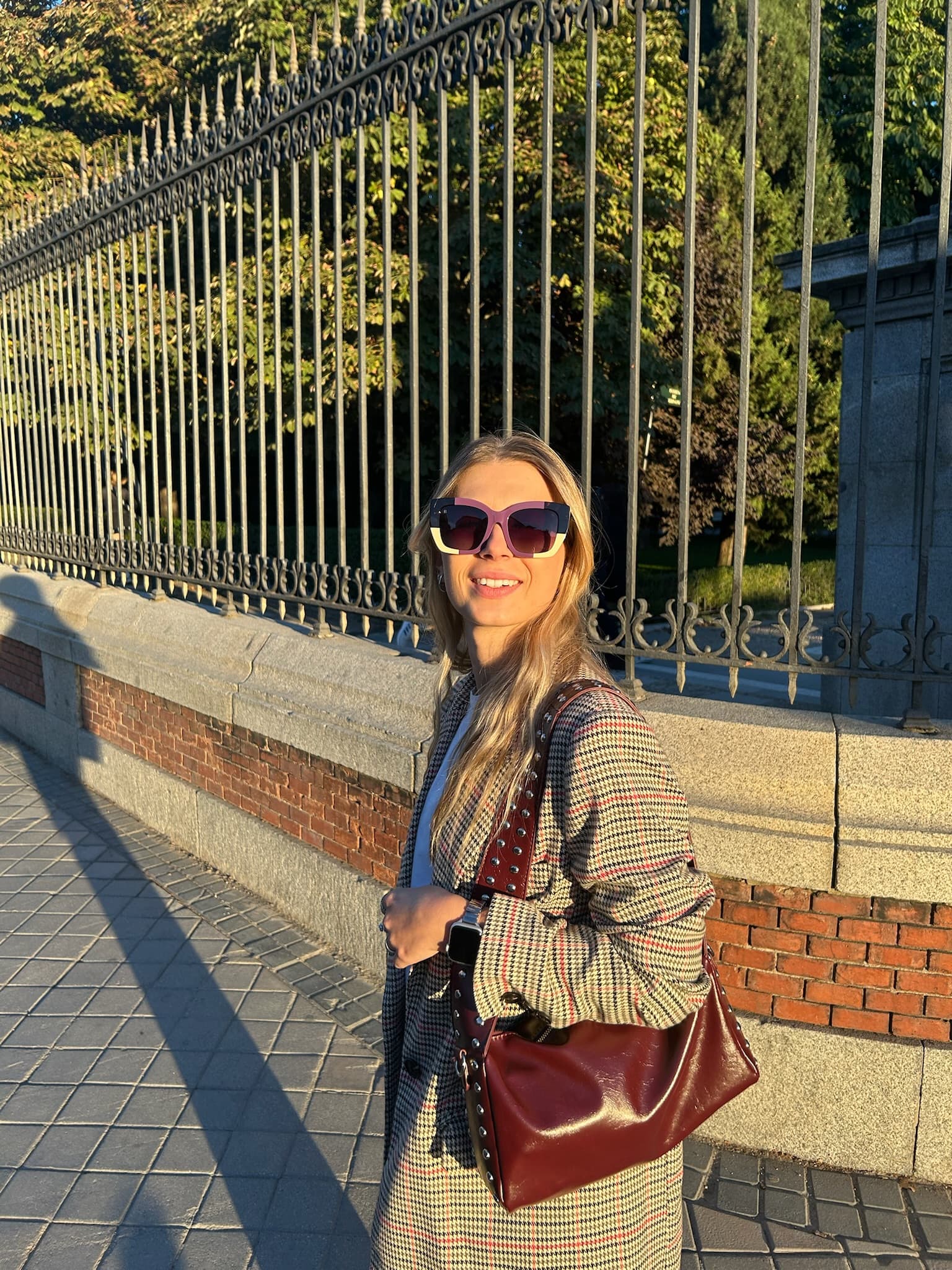 A model walking along an ironwork fence in Madrid wearing the tortoise KOHL frame